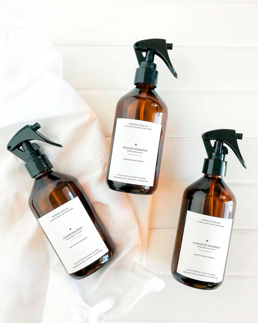 Aromatizador de ambiente no vidro âmbar com gatilho spray nos aromas Caramel Macchiato, Brisa das Montanhas e Croissant de Amêndoas.