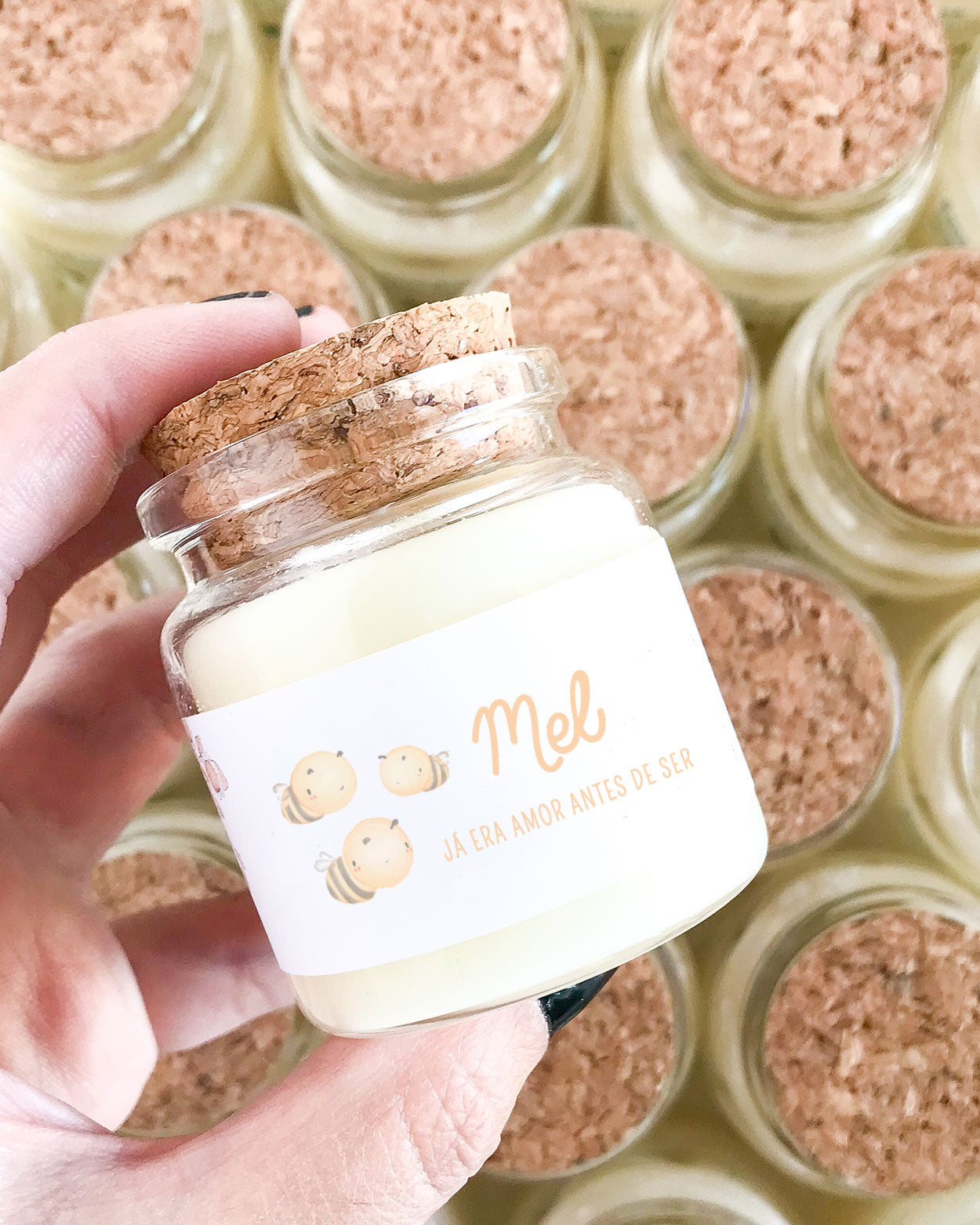 Mini vela feita em um vidro especial com tampa de rolha natural, adesivo com ilustração aquarelada abelhinhas e mensagem personalizada para maternidade. Com o nome do bebê (Mel) e a mensagem: já era amor antes de ser.