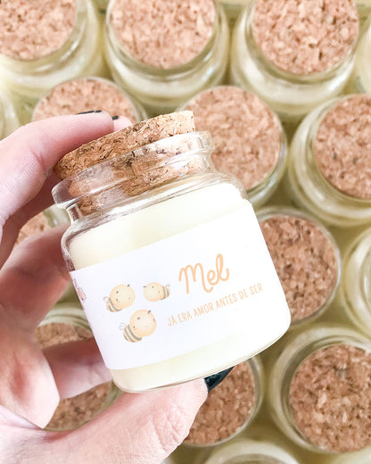 Mini vela feita em um vidro especial com tampa de rolha natural, adesivo com ilustração aquarelada abelhinhas e mensagem personalizada para maternidade. Com o nome do bebê (Mel) e a mensagem: já era amor antes de ser.