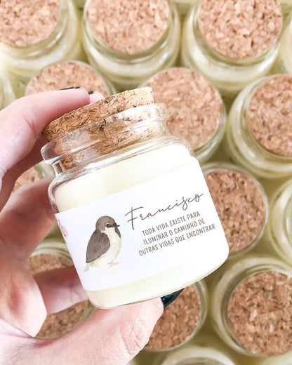 Mini vela feita em um vidro especial com tampa de rolha natural, adesivo com ilustração aquarelada de passarinho minimalista e mensagem personalizada para maternidade. Com o nome do bebê (Francisco) e a mensagem: toda vida existe para iluminar o caminho de outras vidas que encontrar.
