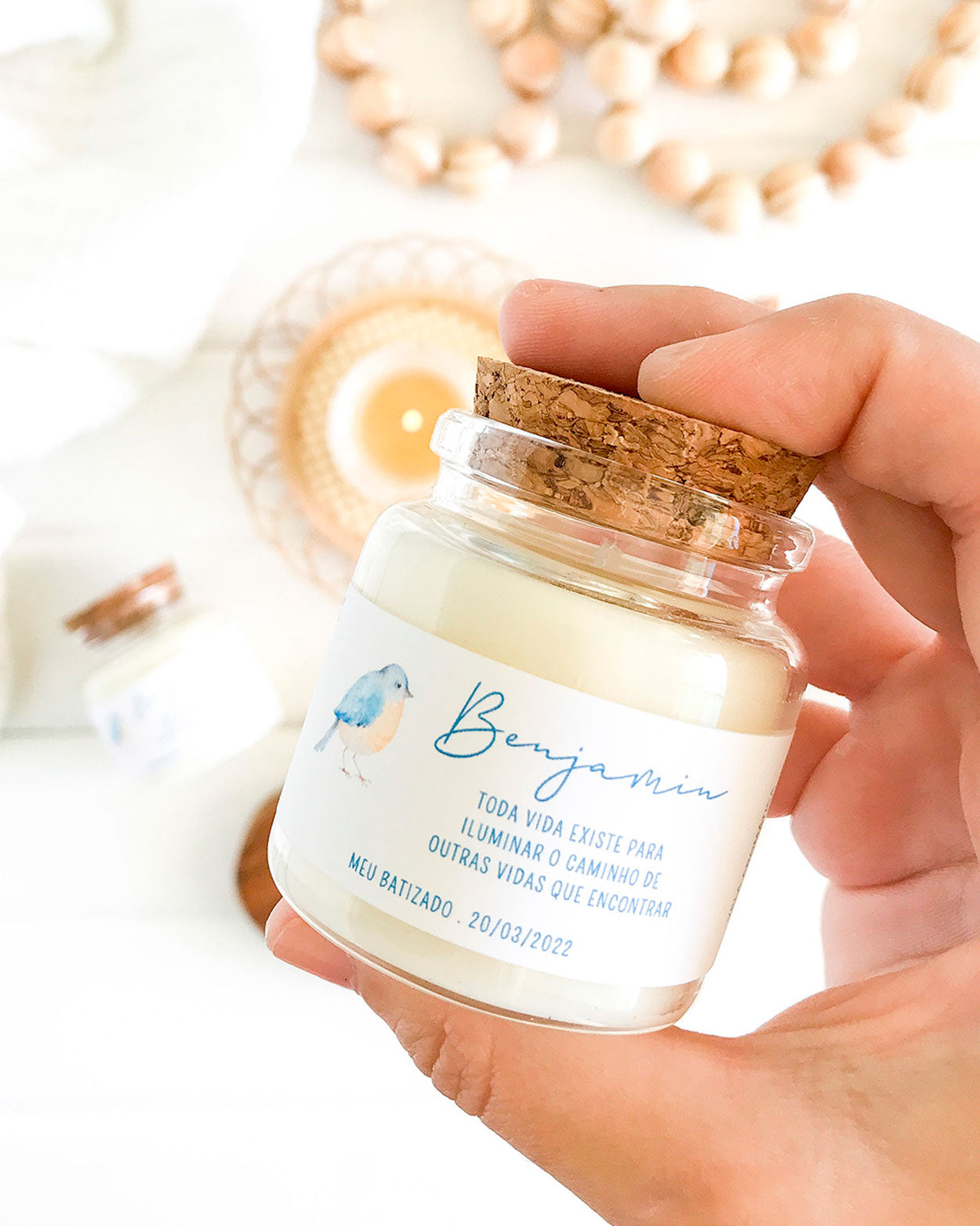 Mini vela feita em um vidro especial com tampa de rolha natural, adesivo com ilustração aquarelada e minimalista de um passarinho e mensagem personalizada para batizado. Com o nome da criança (Benjamim) e a mensagem: toda vida existe para iluminar o caminho de outras vidas que encontrar.